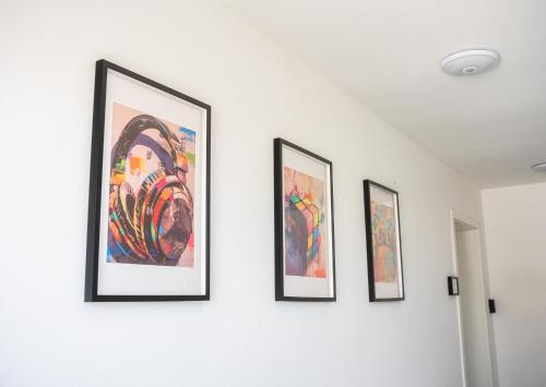 four framed paintings on a white wall at HAMA Design Homes Pader-Stars in Paderborn