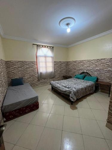 a bedroom with two beds and a window at Banana surf town in Tamraght Ouzdar