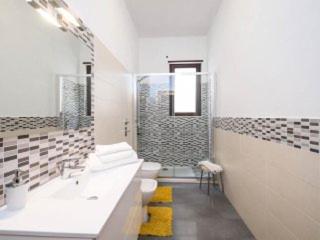 トラーパニにあるAppartamento Uso turistico Da Cristinaの白いバスルーム(シンク2台、シャワー付)