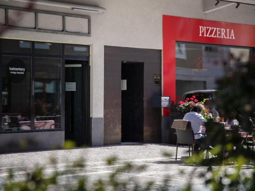 a person sitting at a table outside of a restaurant at Apartment Chesa Ova Cotschna 306 by Interhome in St. Moritz