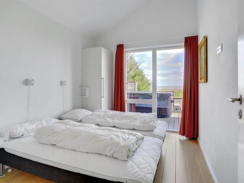 two beds in a room with a large window at Holiday Home Rudolf - 3-5km from the sea by Interhome in Rømø Kirkeby