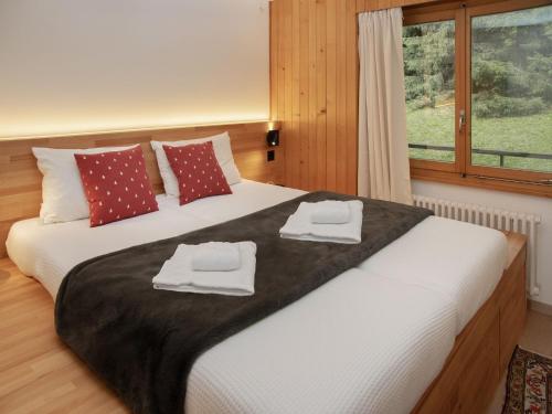 a bedroom with a large bed with towels on it at Apartment Schuss 23 by Interhome in Villars-sur-Ollon