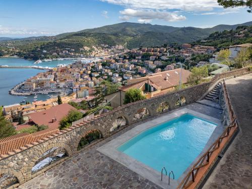 une piscine sur un mur de pierre avec vue sur une ville dans l'établissement Holiday Home Sole by Interhome, à Porto Santo Stefano