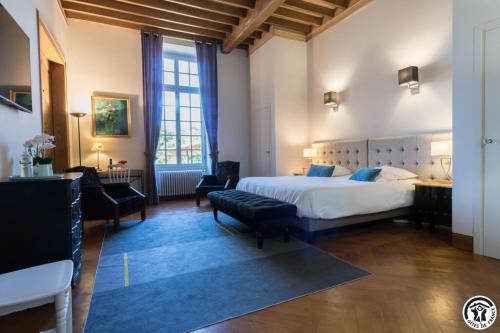 a bedroom with a large white bed and a chair at Chambres d'hôtes de montcausson in Revel