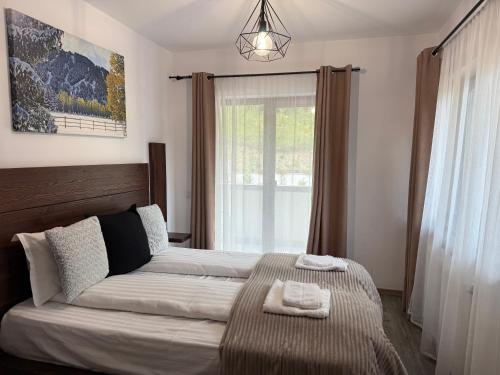 a bedroom with a large bed and a window at Cabana Sun Valley in Moara de Pădure