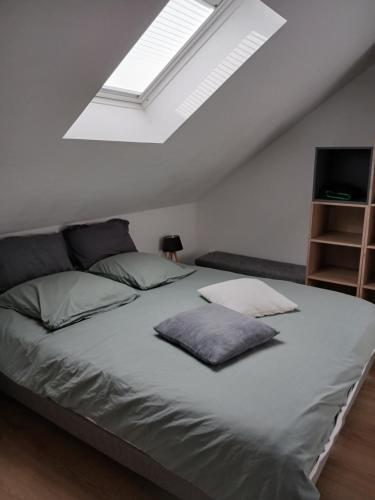 une chambre avec un grand lit avec une lucarne dans l'établissement Les Oyats, à Dunkerque