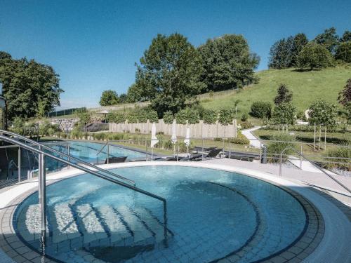 a large swimming pool with a metal handrail in at Heilthermen Resort Bad Waltersdorf in Bad Waltersdorf