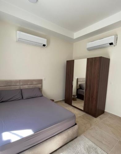 a bedroom with a bed and a mirror at Latin district in New Alamein الحي اللاتيني في العلميين الجديده in El Alamein
