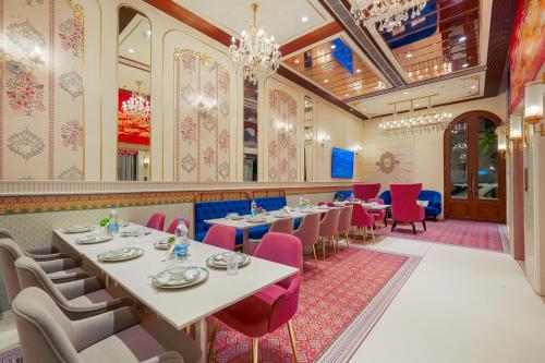 a dining room with tables and chairs and a chandelier at Hotel Red Martin 2 min walk from Golden Temple in Amritsar