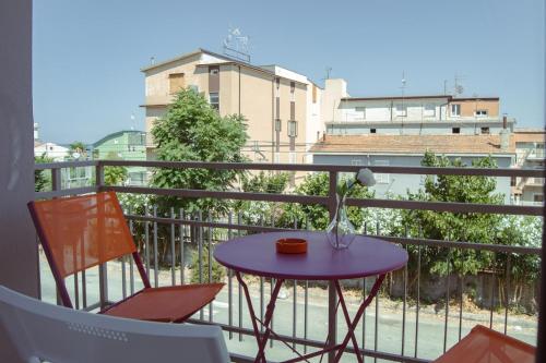 a balcony with a purple table and two chairs at El Gao in Trebisacce