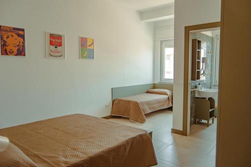 a bedroom with two beds and a sink and a mirror at El Gao in Trebisacce