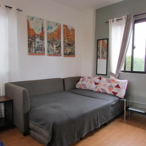 a living room with a couch and some paintings on the wall at Casa Devino - Discover the Perfect Condo Getaway in Luxury, Kareoke, Netflix, Free Parking in Tagaytay