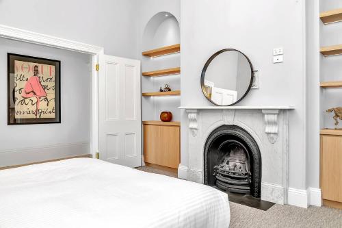Schlafzimmer mit Kamin und Spiegel in der Unterkunft The BeBe on Gover - Heritage Gem in North Adelaide in North Adelaide