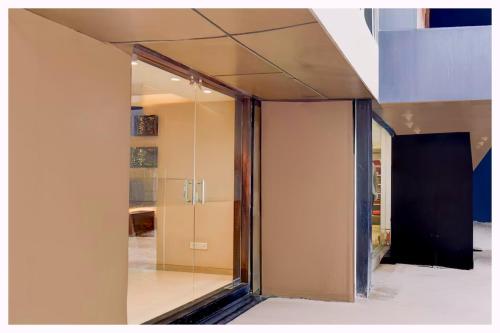 a glass pivot door in a room with a kitchen at Hotel B-Paradise - Near Kashi Vishwanath Temple - Fully Air Conditioned And Spacious Rooms With #Wi-fi - Restaurant And Free Parking Available & Best Hotel In Varanasi - Book Now in Rāmnagar