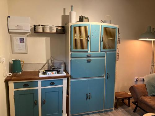 a blue refrigerator in a kitchen with a table at The Shearer's Hut in the Peak Park in Holme