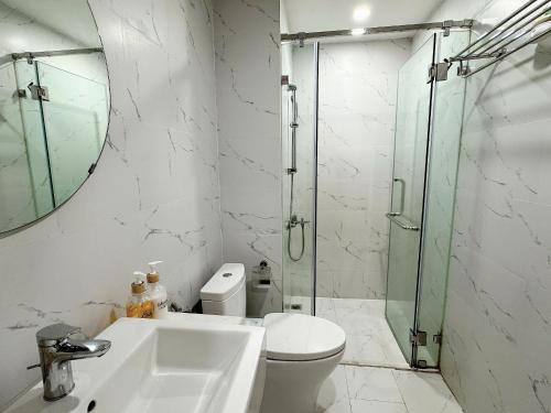 a bathroom with a shower and a toilet and a sink at Seafront Apartment TMS Quy Nhơn in Quy Nhon