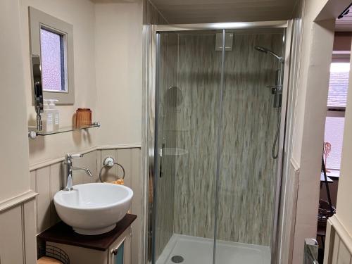 a bathroom with a sink and a shower at The Shearer's Hut in the Peak Park in Holme