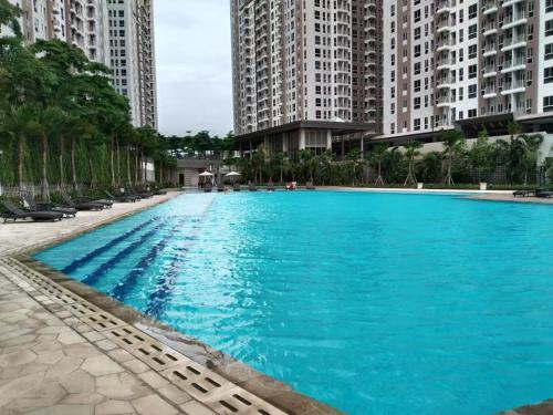 una grande piscina blu con edifici alti di PIK2 Tokyo Riverside Apartment Studio a Muara