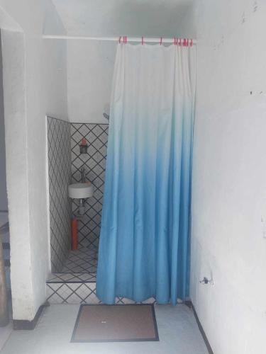 Una cortina azul en una habitación con ducha. en Kylie's Loft House, en Molino