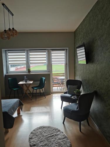 a living room with chairs and a table and window at Gościniec nad Olzą in Cieszyn