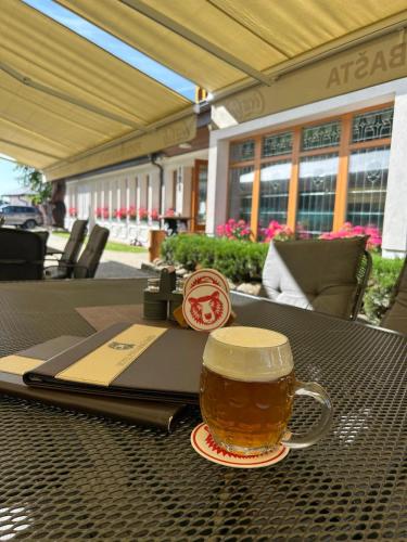 a cup of beer sitting on a table at Hotel Pivovarská bašta in Vrchlabí