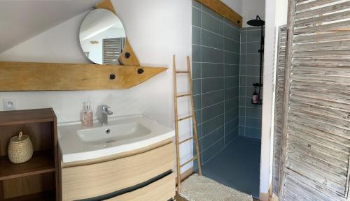 a bathroom with a sink and a mirror and a shower at Maison en pierre, proche du Futuroscope in Scorbé-Clairvaux