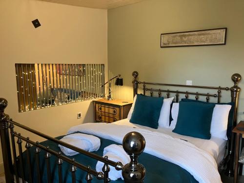 a bedroom with a bed with blue and white pillows at The Shearer's Hut in the Peak Park in Holme