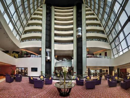 a lobby with purple chairs and a building at Sofitel Al Khobar The Corniche in Al Khobar