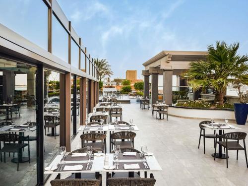 a restaurant with tables and chairs on a patio at Sofitel Dubai Jumeirah Beach in Dubai