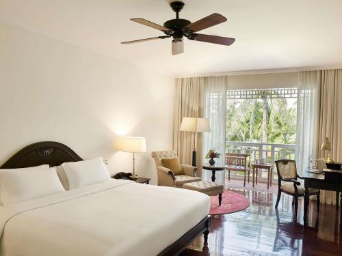 a bedroom with a bed and a living room at Sofitel Krabi Phokeethra Golf and Spa Resort in Klong Muang Beach
