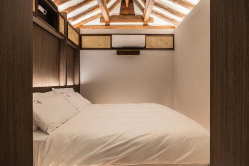 Un pat sau paturi într-o cameră la Luxury Hanok Stay Warm Hearth - West