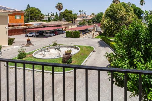 a view of a park with a fountain and a parking lot at Villa Jerez in Jerez de la Frontera