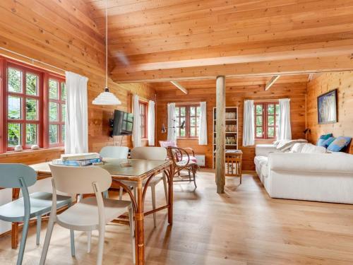 a dining room and living room with wooden ceilings at Holiday Home Henke - 100m from the sea by Interhome in Læsø