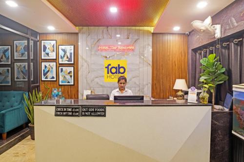 ボーパールにあるFabHotel The Bentree - MP Nagarの女性がロビーのフロントデスクに座っている