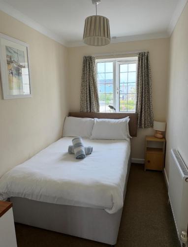 ein Schlafzimmer mit einem großen weißen Bett und einem Fenster in der Unterkunft Pirans Apartments in Perranporth