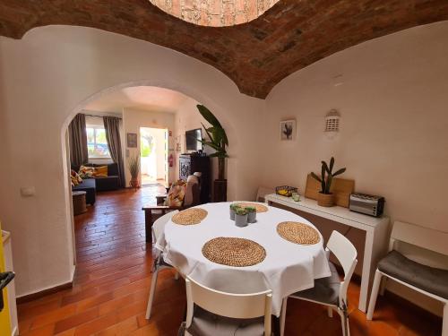 a dining room with a white table and chairs at Aldeia do Golf - Vila I8 in Vilamoura