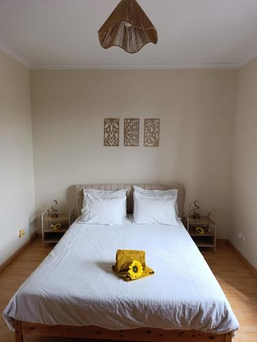 a bedroom with a bed with a yellow object on it at Maison Zita in Venda do Atalhinho