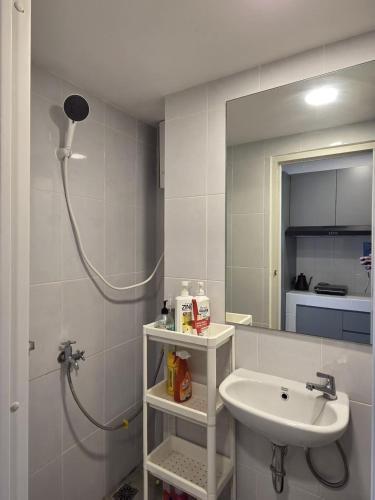 a bathroom with a sink and a shower and a mirror at PIK2 Tokyo Riverside Apartment Studio in Muara