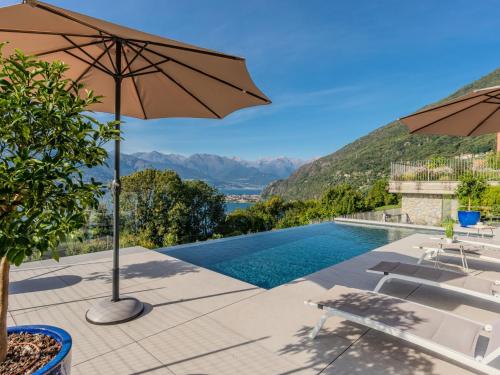 a villa with a swimming pool and an umbrella at Holiday Home La Terrazza sul Lago by Interhome in Bellano