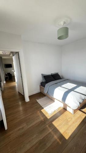 a bedroom with a bed and a wooden floor at Superbe appartement en Hauteur style NEW Yorkais - Proche Métro Paris Idéal pour couple et professionnels Toutes commodités à proximité in Saint-Ouen