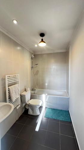 a bathroom with a toilet and a tub and a sink at Superbe appartement en Hauteur style NEW Yorkais - Proche Métro Paris Idéal pour couple et professionnels Toutes commodités à proximité in Saint-Ouen