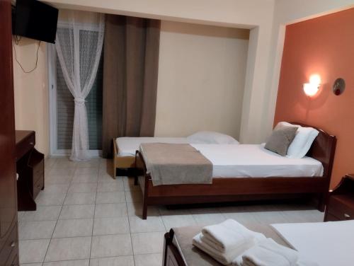 a hotel room with two beds and a window at House Aggeliki in Kalamitsi
