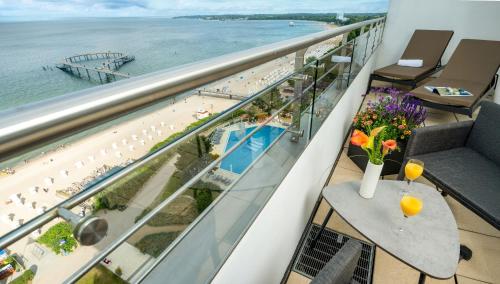 a balcony with a view of the beach and the ocean at Maritim Seehotel Timmendorfer Strand in Timmendorfer Strand