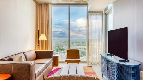 a living room with a couch and a large window at Natiivo by AvantStay in Austin
