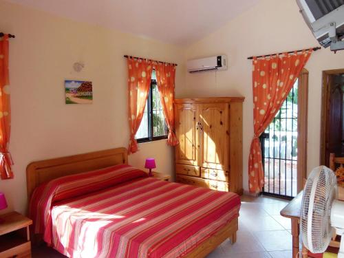 a bedroom with a bed with a red and white striped blanket at Casa Lily & Coco in Las Terrenas