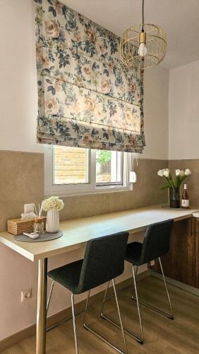 a kitchen with a table with chairs and a curtain at Sunshore Center apartment #3 in Chalkida