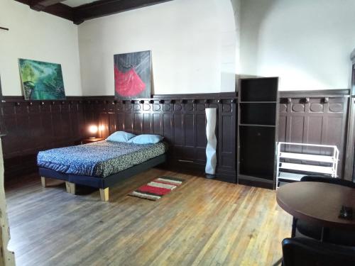 a bedroom with a bed and a wooden floor at Hostal Casona Portugal in Santiago