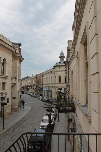 una calle de la ciudad con coches aparcados y un edificio en Guesthouse Medea on Pushkini 4, en Kutaisi