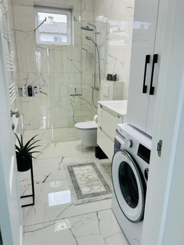 ein weißes Badezimmer mit einer Waschmaschine darin in der Unterkunft Blue Queen in Fălticeni