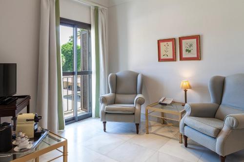 a living room with two chairs and a television at Villa Jerez in Jerez de la Frontera